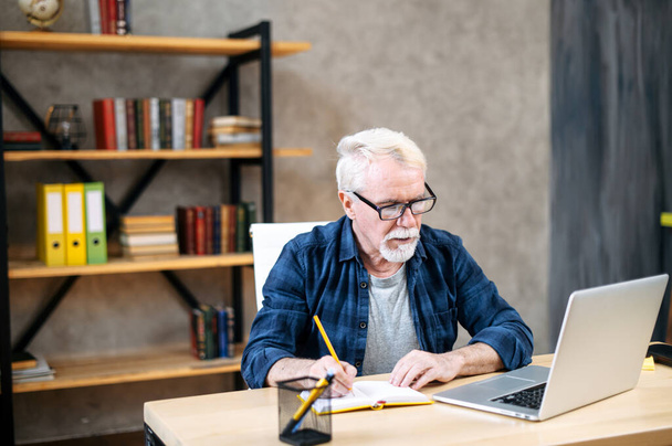 Older man using laptop for studying, working - Фото, зображення