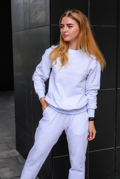 Portrait shooting of a stylish girl. Beige shades. Trends of spring and summer 2020.White sport suit.Jogers - Photo, Image