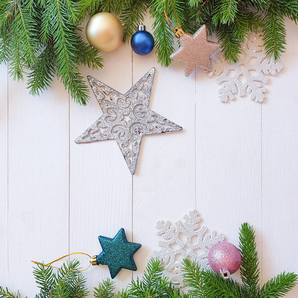 Top view of Christmas fir and stars frame / border on a shabby white wooden table. Place for your text or product. Close-up, Christmas / New Year flatlay. - Foto, Bild