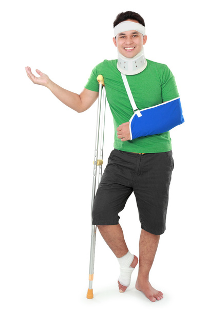male with broken arm and crutch presenting - Foto, Imagen