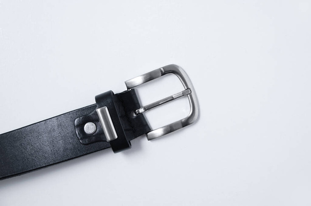 Metal buckle of a male black leather belt on a white background close-up. - Photo, Image