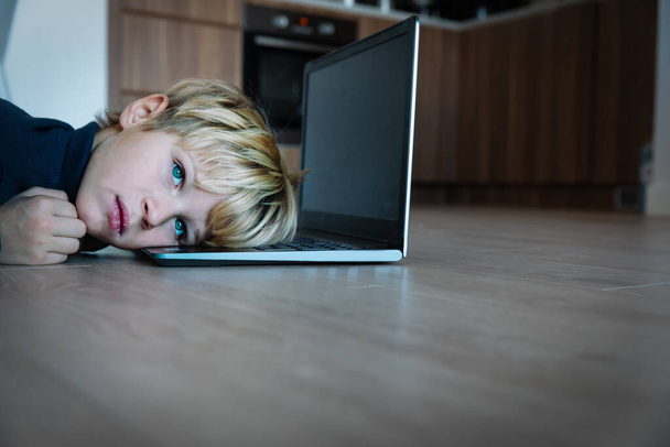 Adolescent ennuyé et triste regardant l'ordinateur, enfant fatigué de l'apprentissage en ligne - Photo, image