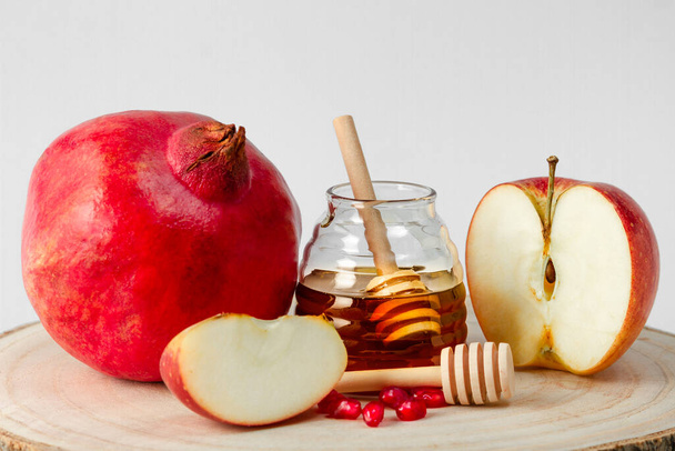 軽い背景にザクロ、リンゴと蜂蜜、ユダヤ人の新年のお祝いの伝統的な食べ物、ロシュ・ハシャナー. - 写真・画像