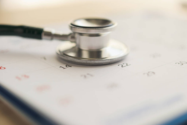 Stetoscopio con calendario pagina data su tavola di legno sfondo medico appuntamento concetto medico - Foto, immagini