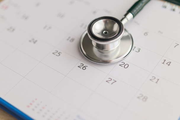 Estetoscopio con calendario página fecha en tabla de madera fondo médico cita concepto médico - Foto, Imagen