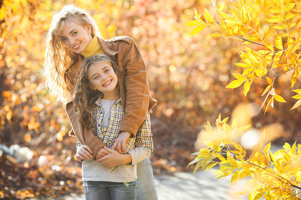 Two girls together outdoors on autumn background - Foto, imagen