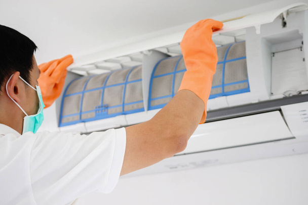 Asian man cleaning air conditioner dirty filter - Foto, imagen