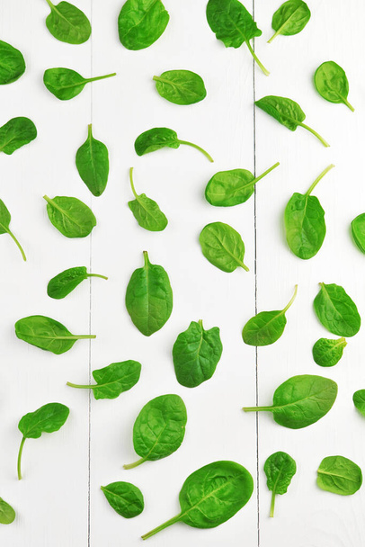 Spinach leaves on white wooden table background. Healthy vegan food trend. Green living concept. Top view. - Φωτογραφία, εικόνα
