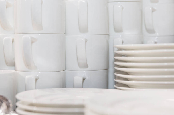 A set of white cups and plates are stacked for a banquet. Drinking coffee at conferences and business meetings. Close-up. - Foto, Bild