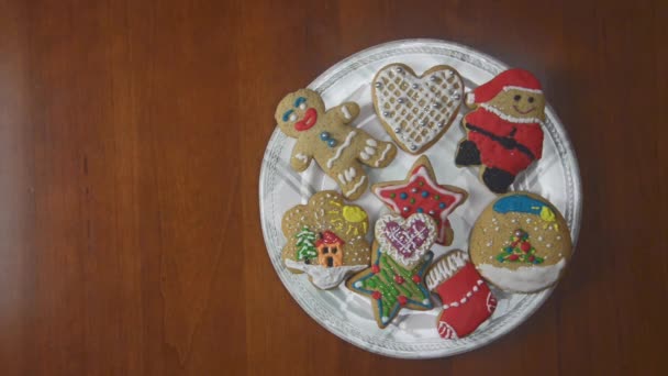 Porcelain plate full of ginger cookies on a wooden table. Every one second, one by one, cookies are disappearing. Last cake is a star figure. - Footage, Video