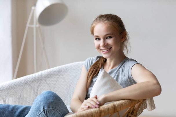 Serene pretty relaxed young woman on cozy chair in living room dreaming, feel no stress. Enjoying resting at home.  - Foto, Bild