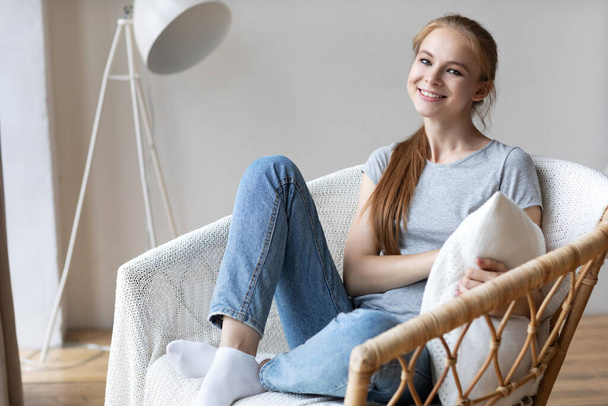 Portrait of a beautiful woman relaxing sitting on a chair at home. Domestic life. - Foto, imagen