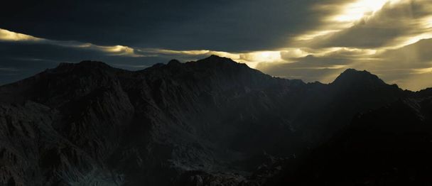 Majestuosa vista del paisaje de las montañas en la noche oscura con cielo colorido - Foto, imagen
