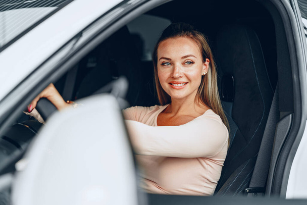 Young attractive caucasian woman sits in her newly bought car - Foto, Imagen