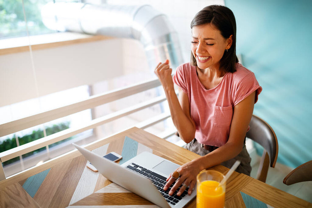 Portrait of a cheerful woman working, studying on a laptop - Foto, afbeelding