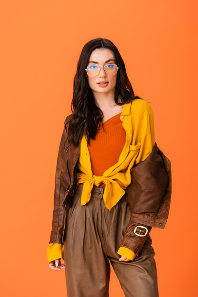 young woman in autumn outfit and glasses looking at camera isolated on orange  - Φωτογραφία, εικόνα