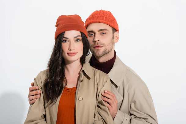 man in beanie hat touching stylish young woman on white - Photo, Image