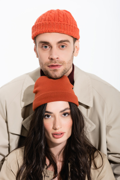 mężczyzna w czapce kapelusz i stylowe młoda kobieta patrząc na aparat odizolowany na biały - Zdjęcie, obraz