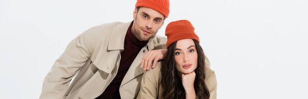 panoramic concept of trendy man in beanie hat leaning on brunette woman isolated on white  - Fotó, kép