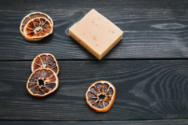 Natural citrus soap on dark background. Concept of Spa, Salon or Home body and skin care. Flat lay. Space for text, top view - Fotó, kép
