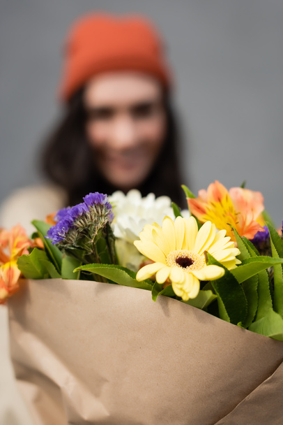 selektivní zaměření kytice s květinami v blízkosti ženy - Fotografie, Obrázek