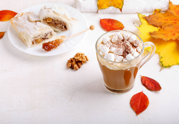 Autumn composition with cup of hot drink, delicious apple strudel   and colorful fall leaves on white background. Copy space. Autumn mood, fall season concept. - Photo, Image