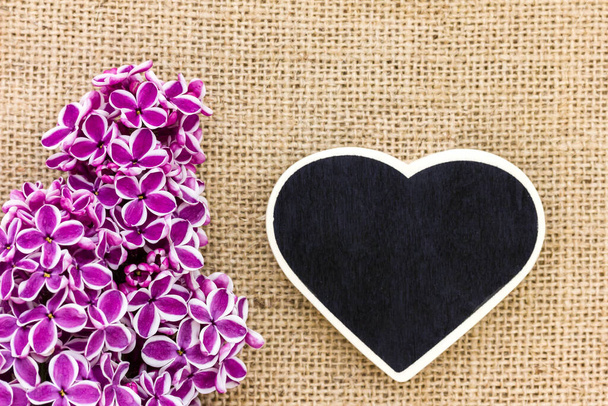 fialové šeříky a černé srdce jako pozadí - Fotografie, Obrázek