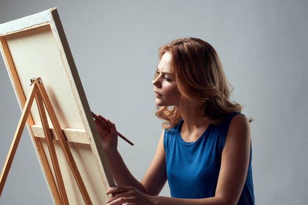 Kobieta artystka z farbą pędzla na sztaludze sztuka hobby lekkie tło - Zdjęcie, obraz