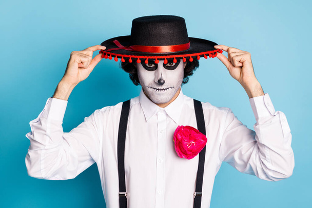 Close-up portrait of his he handsome scary spooky imposing guy gentleman wearing sombrero Santa Muerte cult ritual carnival isolated bright vivid shine vibrant blue color background - 写真・画像