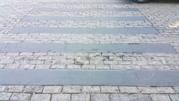 Πεζόδρομος, φτιαγμένος από πέτρες. Μονοπάτι Κόμπλστοουν. Crosswalk στο δρόμο για την ασφάλεια όταν οι άνθρωποι που περπατούν διασχίζουν το δρόμο. - Φωτογραφία, εικόνα