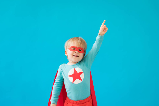 Portrait of superhero child. Super hero kid against blue background. Success and winner concept - Zdjęcie, obraz