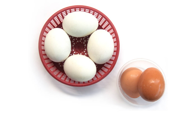 Suolattu muna ja kananmuna muovikorissa valkoisella pohjalla - Valokuva, kuva