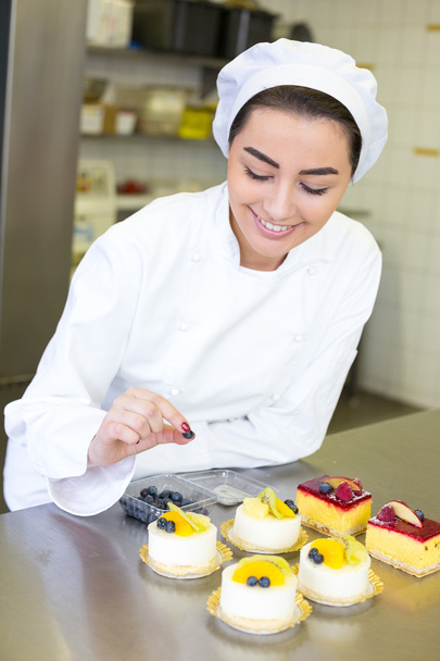 Confectioner preparing cakes at bakery or confectionery - Foto, Bild