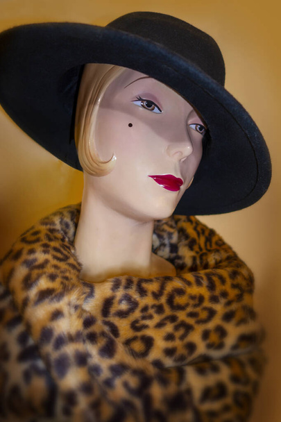 stylish ceramic torso mannequin with black brim hat with leopard fur scarf around neck - Фото, изображение