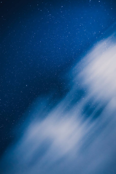 Vertikale Ansicht eines nachtblauen Himmels mit Sternen in der Landschaft. Milchstraße unter den Wolken. - Foto, Bild