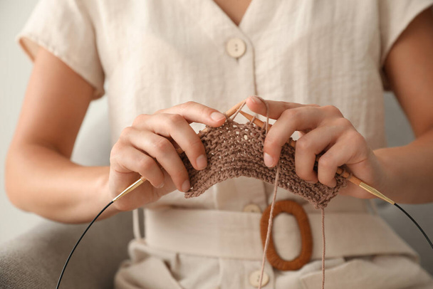 Mujer joven tejiendo con agujas en el interior, primer plano. Participar en el hobby - Foto, Imagen