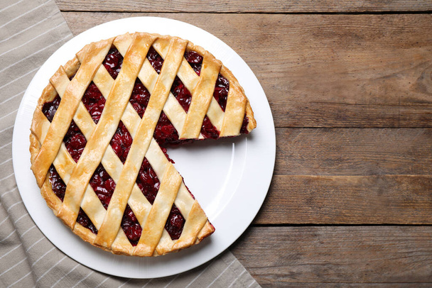 Delicious fresh cherry pie on wooden table, flat lay - Foto, immagini