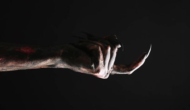 Scary monster on black background, closeup of hand. Halloween character - Foto, Imagen