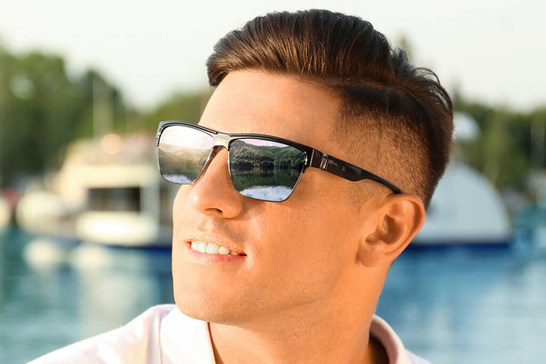Happy man on vacation. Mountains and lake mirroring in his sunglasses - Φωτογραφία, εικόνα