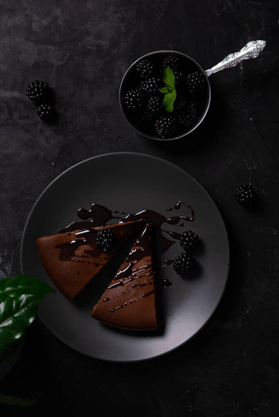 Chocolate cake with berries in a low key flatlay - Фото, изображение