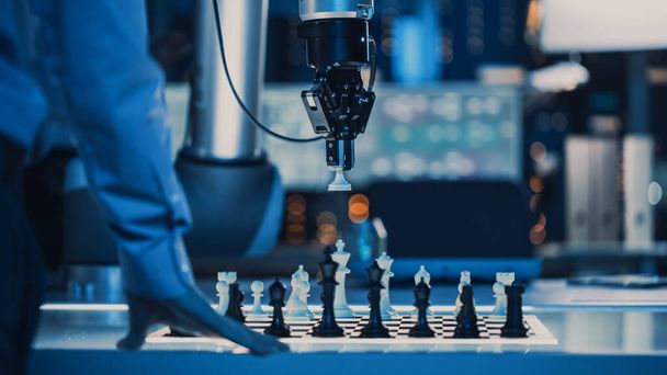 Close Up Shot of a Artificial Intelligence Operating a Futuristic Robotic Arm in a Game of Chess Against a Human. Robot Moves a Pawn. They are in a High Tech Modern Research Laboratory. - Foto, Imagem