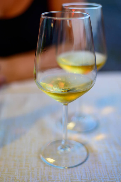 Two glasses of cold dry white wine served outdoor in cafe at night in Italy close up - Foto, Bild