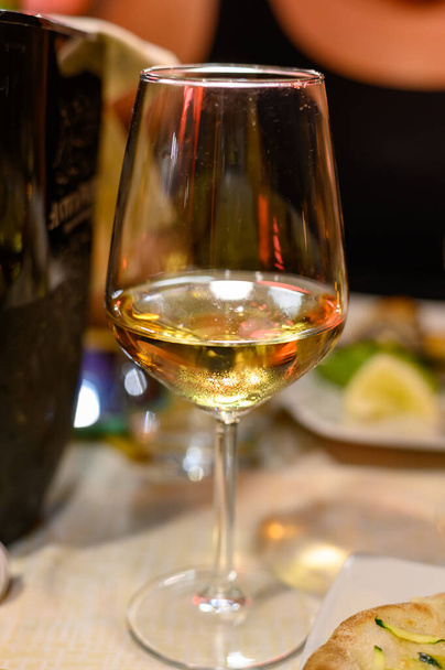Вночі в Італії біля кафе подавали склянку холодного сухого білого вина. - Фото, зображення