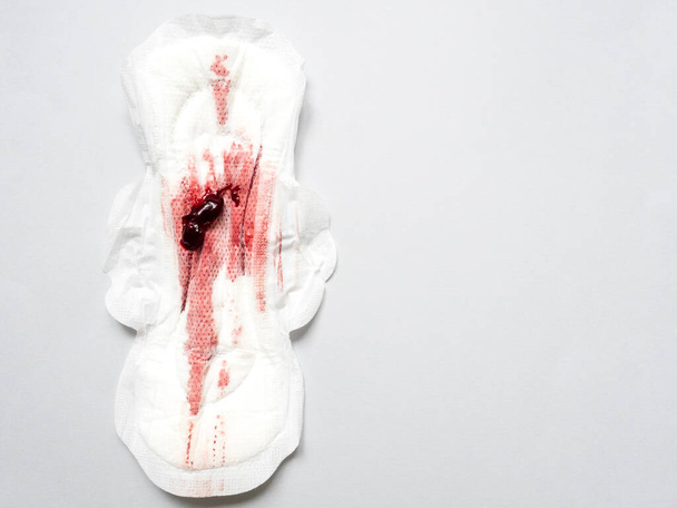 Symptom of endometriosis, menstrual blood with blood clots on a sanitary pad. - Photo, Image