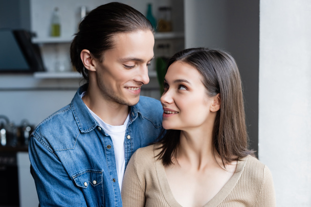 young couple looking at each other while standing together at home - Foto, immagini