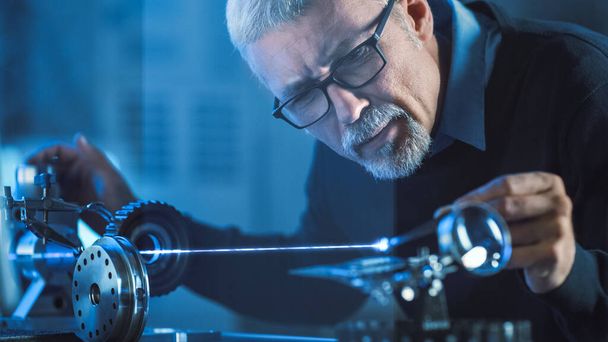 Close-up Portrait of Focused Middle Aged Engineer in Glasses Working with High Precision Laser Equipment, Using Lenses and Testing Optics for Accuracy Required Electronics - Fotoğraf, Görsel