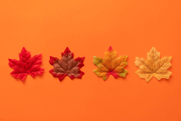 Composition avec de fausses feuilles d'automne sur fond orange. - Photo, image