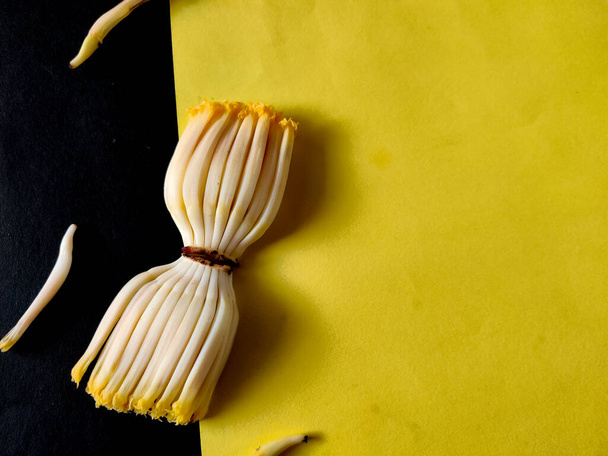 Kaksi joukko kypsentämättömiä banaanin florets eristetty musta ja keltainen tausta, Copyspace - Valokuva, kuva