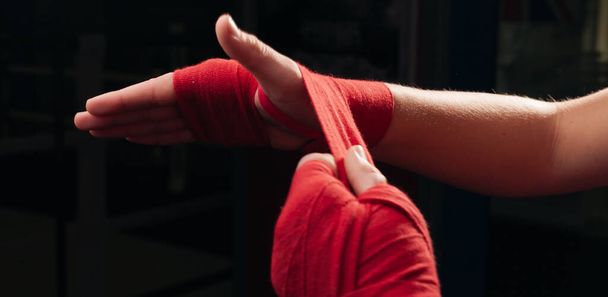 Boxeador chica en rojo bandas de boxeo de cerca. - Foto, imagen