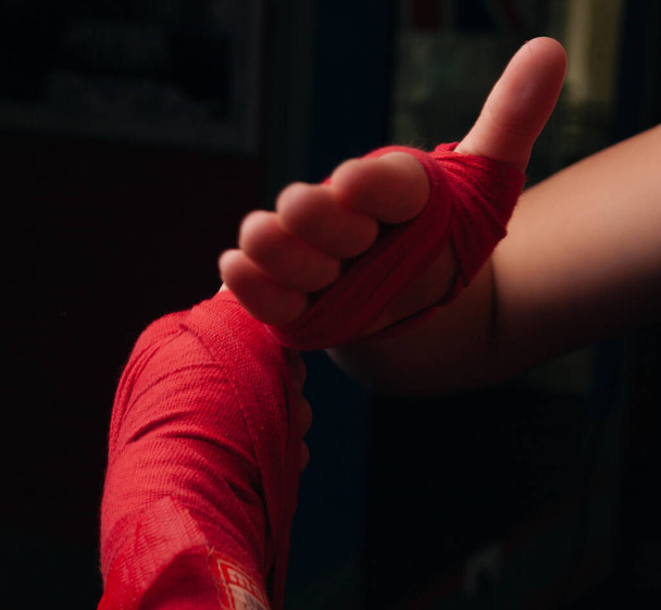Boxer girl in red boxing bands close-up. - Photo, Image